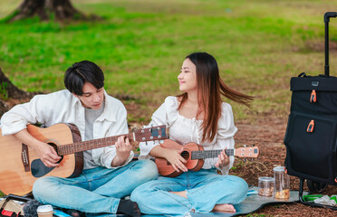 Asian Couple Playing Guitar Outdoors