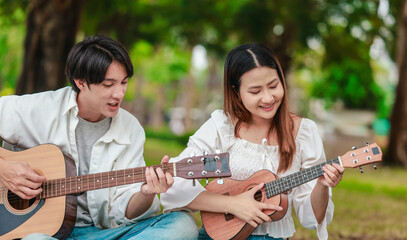 Asian Couple Playing Guitar Outdoors
