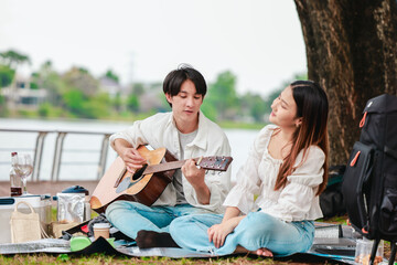 Asian Couple Playing Guitar Outdoors