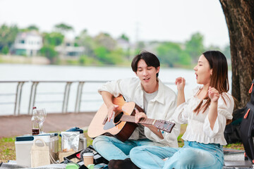 Asian Couple Playing Guitar Outdoors