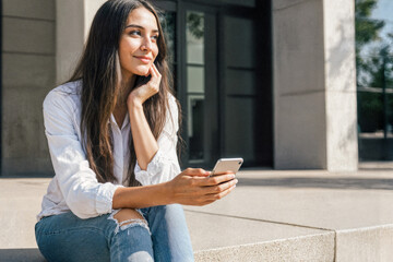 Pensive Woman with Phone on Urban Steps