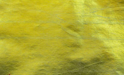 Shiny gold foil texture with crinkled and metallic surface. Ideal for luxury design, festive...