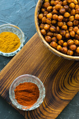 Delicious snack, fragrant baked with curry spices and smoked paprika chickpeas in a brown bowl and...