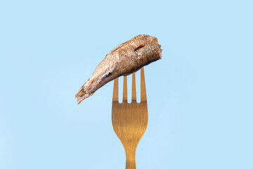 Sardinecore trend concept, canned sardines in metal can on a blue background, on plate with a fork...