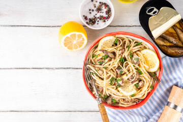 Sardinecore trend food, sardine pasta for dinner in plate on kitchen table. Spaghetti pasta with...
