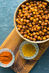 Delicious snack, fragrant baked with curry spices and smoked paprika chickpeas in a brown bowl and...