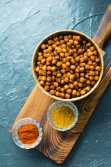 Delicious snack, fragrant baked with curry spices and smoked paprika chickpeas in a brown bowl and...