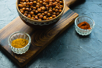Delicious snack, fragrant baked with curry spices and smoked paprika chickpeas in a brown bowl and...