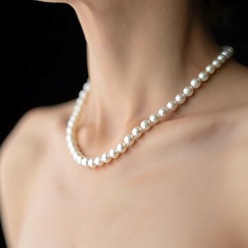 Fashionable woman models a beautiful pearl necklace, enhancing her glamour and sensuality