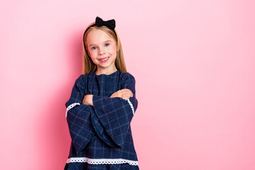 Smiling girl posing confidently against a vibrant pink background, wearing a stylish blue dress...