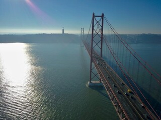 Aerial View of Suspension Bridge Over Sunlit River at Sunset, Lisbon - Alcantara