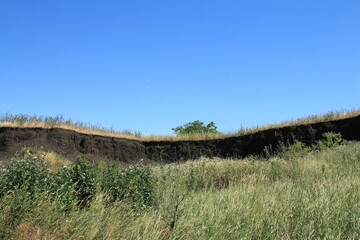 A grassy hill with a hill in the background