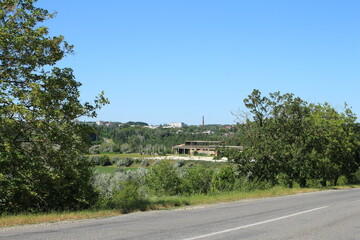 A road with trees and a building in the background