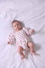 Cute newborn baby lying on bed, top view