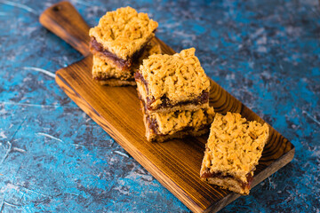 Delicious homemade pie with apple jam. Crispy pieces of grated pie with jam on a wooden board close-up, apple and cinnamon aroma