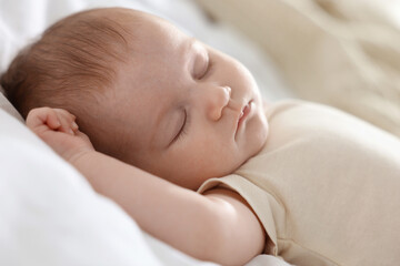Cute newborn baby sleeping on bed indoors