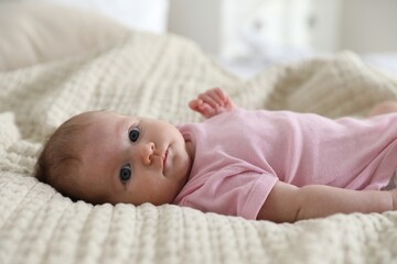 Cute newborn baby lying on bed indoors