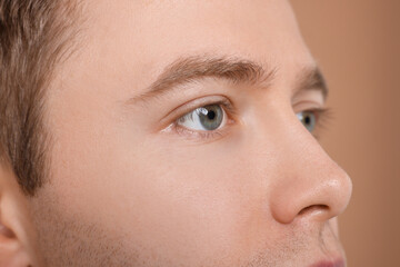 Handsome man on beige background, closeup view