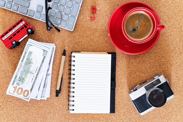 Travel planning desk with coffee and cash. Flatlay workspace for vacation budgeting.