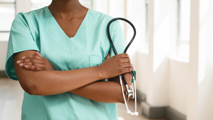 Female Nurse Holding Stethoscope in a Bright Hospital Corridor Symbolizing Medical Care
