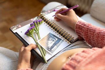 Pregnant woman writing in her diary