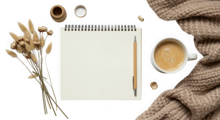 Flat lay of notebook, pen, coffee, dried flowers, and knit blanket on transparent background