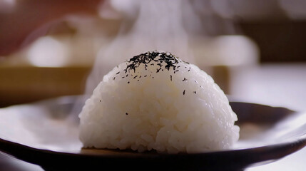 Steaming rice ball topped with black sesame seeds on dark plate, showcasing traditional Japanese dish. warm, inviting aroma enhances experience