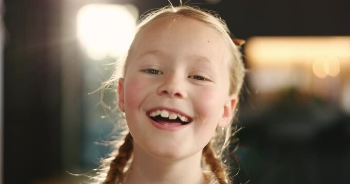 Happiness, laughing and face of girl in home for growth or on weekend in living room. Smile, child and portrait of playful female kid in house for funny joke, satisfaction or childhood in Australia