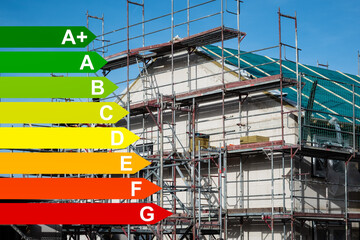 Gerüst vor einem Neubau eines gedämmten Einfamilienhauses, Grafiken mit Energieeffizienzklassen...