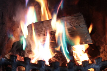 Close-up of log fire with multi-coloured firelighter flames