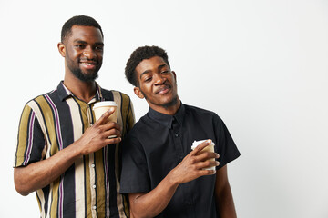 Two black men enjoying coffee together, smiling brightly in casual clothing. Capturing friendship...