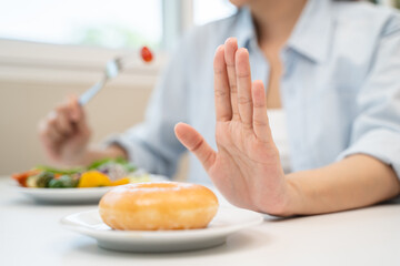 Diet food loss weight concept, Hand of woman pushing sweet away and avoid to eat fried chicken to...