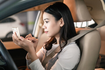 
Young professional women in China are doing their makeup in a small car
