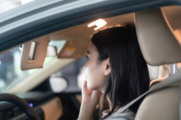
Young professional women in China are doing their makeup in a small car
