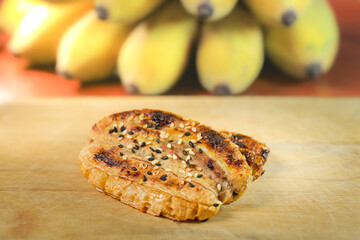 Thai grilled bananas serve with honey or coconut caramel syrub. Selective focus and free space for...