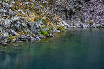 Rugged Slate Cliffs and Rocky Shoreline of a Disused Mine Lake