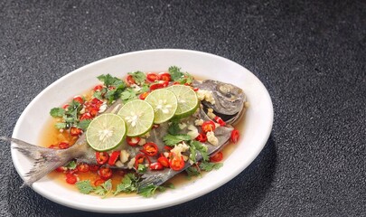Thai steamed fish served with a bright, punchy  with lots of lime, garlic, chillies, fish sauce and other fragrant aromatics.