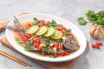 Thai steamed fish served with a bright, punchy  with lots of lime, garlic, chillies, fish sauce and other fragrant aromatics.