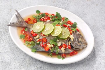 Thai steamed fish served with a bright, punchy  with lots of lime, garlic, chillies, fish sauce and other fragrant aromatics.