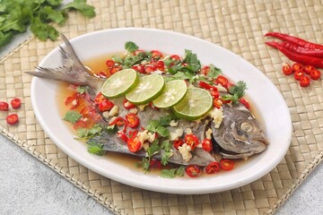 Thai steamed fish served with a bright, punchy  with lots of lime, garlic, chillies, fish sauce and other fragrant aromatics.