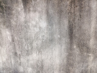 A textured concrete or stone surface exhibiting a gradient of dark to light gray tones with subtle variations and streaks, creating an abstract and distressed background. Related to texture overlay