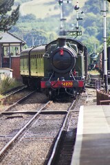 Steam train arriving at retro railway station, Midlands, UK