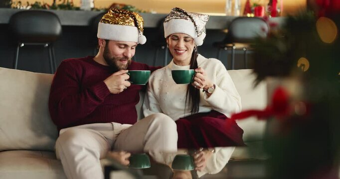 Happy couple, cheers or sofa with coffee for christmas celebration or december holiday in home. Man, woman and kiss on cheek with love, cup or mug for bonding, festive or christian tradition in house