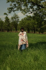 A Kashmiri man wrapped in a handcrafted floral Kaar Kash carpet — where tradition becomes...