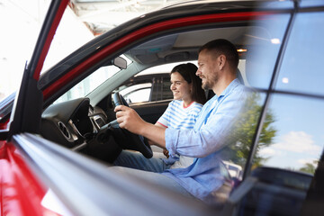 Happy family sitting inside new car. Luxury vehicle