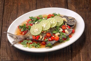 Thai steamed fish served with a bright, punchy  with lots of lime, garlic, chillies, fish sauce and other fragrant aromatics.