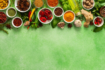 A vibrant assortment of fresh, multicolored spices and herbs on a delicate green background,...