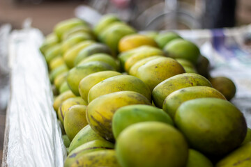A bunch of yellow ripe mango. Many have become a pile together and look like the background.