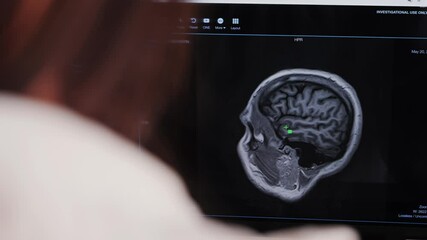 A female doctor examines MRI scans in her office of the modern clinic. Diagnostic technology for accurate and efficient medical care. High quality 4k footage - Powered by Adobe