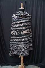 Elegant display of Kashmiri shawls draped on a mannequin, featuring intricate Sozni embroidery that...